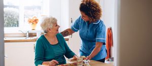 In-home care provider helping elderly client eat