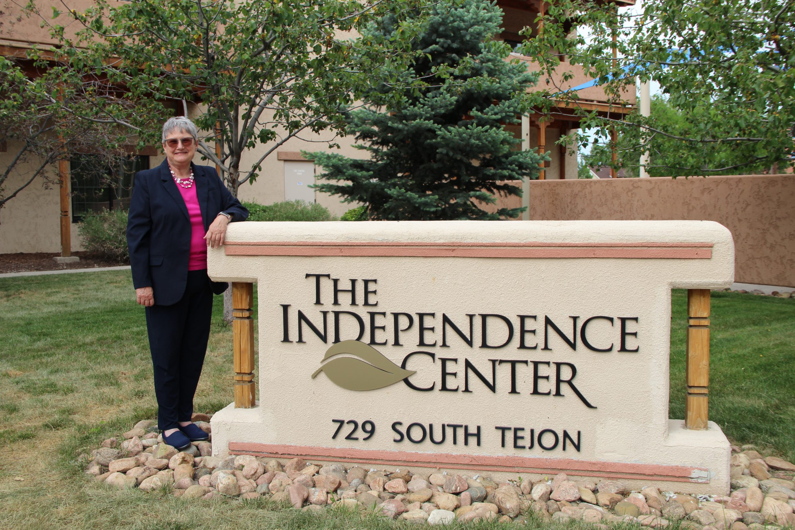 Patricia Yeager standing next to The Independence Center sign